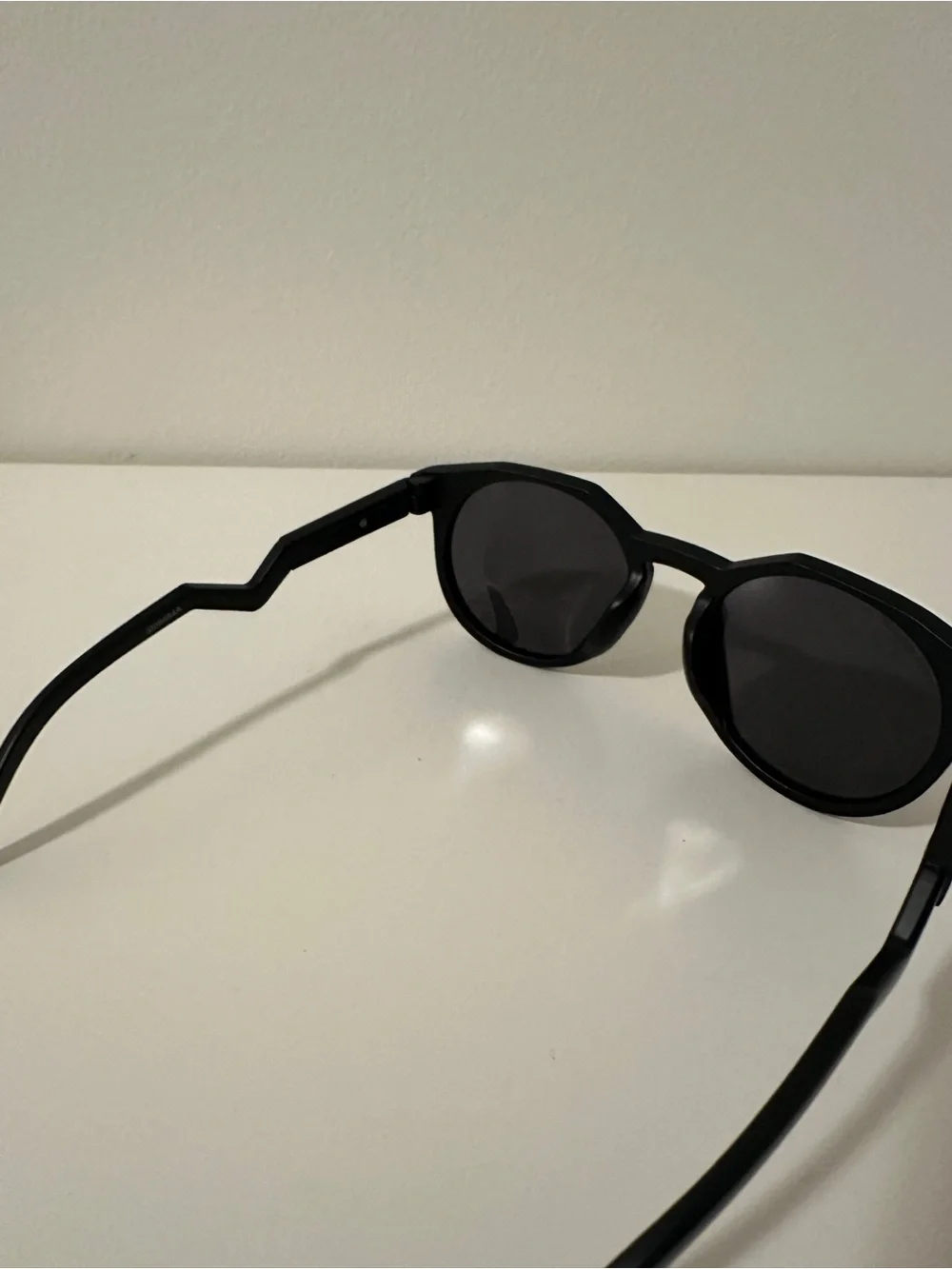 Oakley Black Round Sunglasses with Zigzag Temples and White Logo Accents